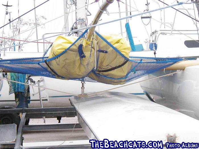 Forward corner passes over pole and is stretched to attach to a piece of line that passes through the spinnaker pole.