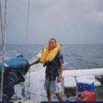 The skipper/owner, Mark, demonstrates to the crew how a auto inflate life vest works.